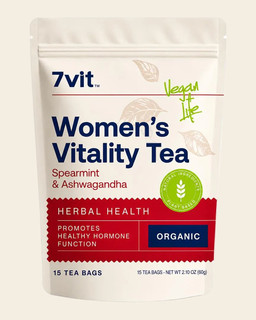 A stand-up pouch of 7vit Women's Vitality Tea in Spearmint & Ashwagandha flavor. The packaging is off-white with navy blue text, a red banner, and a green circular 'Vegan Life' logo, set against a plain white background.